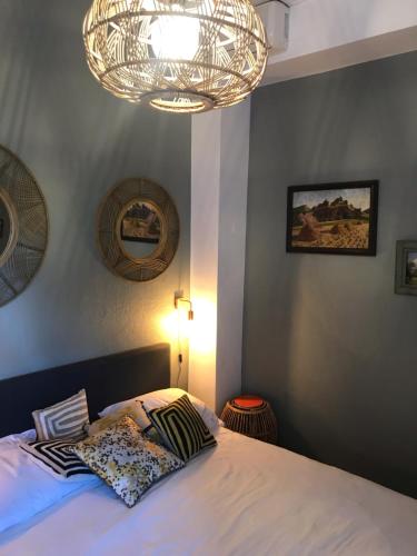 a bedroom with a bed and a chandelier at Chambre Rose in Bastia