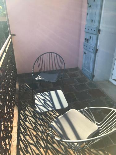 a chair and a table on a balcony at Chambre Rose in Bastia