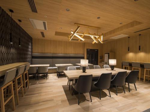 a dining room with tables and chairs and a chandelier at Tmark City Hotel Kanazawa in Kanazawa
