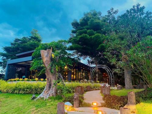 a tree in front of a building with a walkway at Baan Suan Leelawadee Resort Nan in Nan