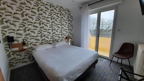 a bedroom with a bed and a large window at Au Bon Accueil in Perros-Guirec