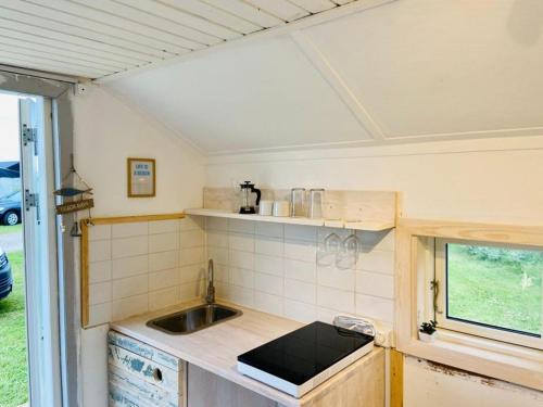 
a white stove top oven sitting under a window at Dancamps Holmsland in Hvide Sande
