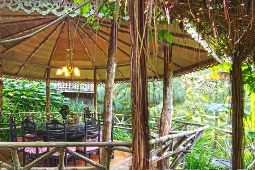 a patio with a table and chairs under an umbrella at Fig Tree Hills Resort (花果山度假村) in Bayan Lepas