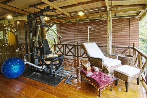 una sala con palestra dotata di tapis roulant e sedia di Fig Tree Hills Resort (花果山度假村) a Bayan Lepas