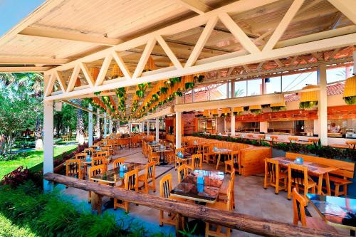 um restaurante com mesas e cadeiras de madeira num campo em Belconti Resort Hotel em Belek