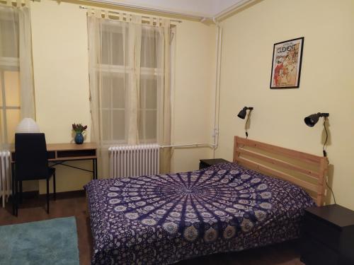 a bedroom with a purple bed and a desk and window at Napraforgó apartman Tokaj in Tokaj