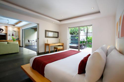 a bedroom with a large bed and a living room at Bali Island Villas and Spa Seminyak in Seminyak