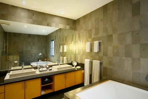 a bathroom with two sinks and a large mirror at Bali Island Villas and Spa Seminyak in Seminyak