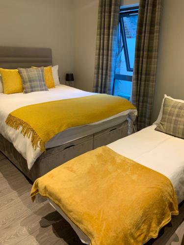 two beds sitting next to each other in a bedroom at York Staycation with Free Parking in York