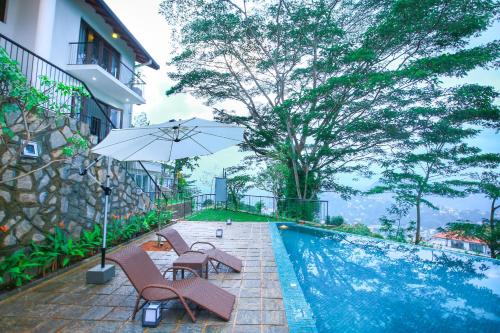 a pool with chairs and an umbrella next to a building at 88th Hanthana in Kandy