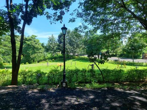 a lamp post in a park with a field at Destination A1 32 Villa in Neral