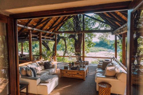 a living room with couches and a table at Karongwe Portfolio - Kuname Lodge in Karongwe Game Reserve