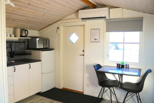 eine kleine Küche mit einem Tisch und 2 Stühlen in der Unterkunft Kärraton Stugor in Åhus