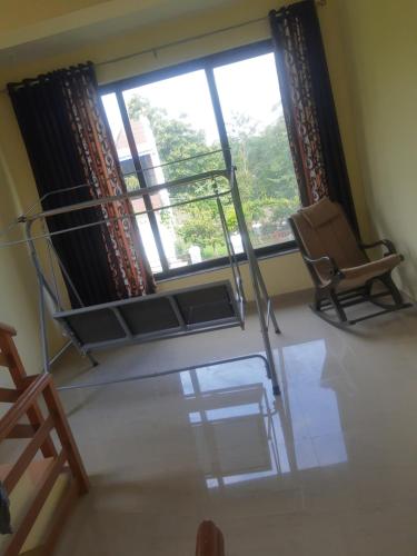 a room with a chair and a large window at Destination A1 32 Villa in Neral