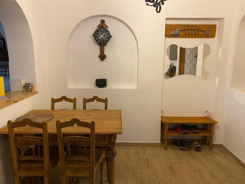 a dining room with a table and a clock on the wall at Penzio Ostrava in Ostrava