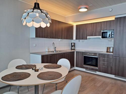 Una cocina con una mesa y sillas en una habitación. en Timantti B13, en Kalajoki