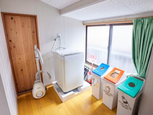 een badkamer met een wasmachine in een kamer bij Hanareya in Tsushima