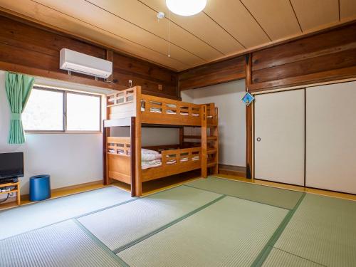 een kamer met een stapelbed en een televisie bij Hanareya in Tsushima