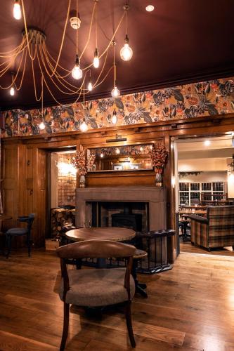 a dining room with a table and a fireplace at The Stanneylands in Wilmslow