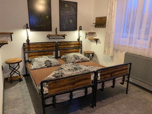 1 dormitorio con 2 camas de madera y ventana en Penzio Ostrava, en Ostrava