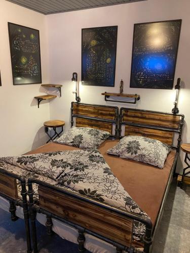 two beds in a room with paintings on the wall at Penzio Ostrava in Ostrava