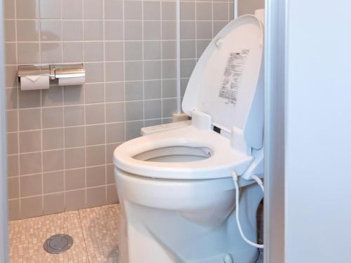 a bathroom with a toilet with the lid up at Sakura Ryokan Asakusa Iriya in Tokyo