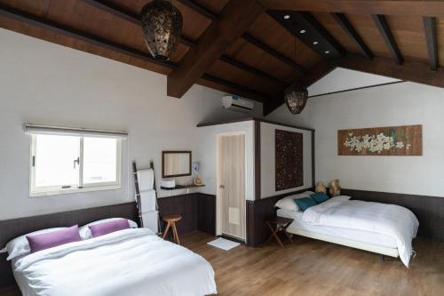 Un dormitorio con dos camas y una ventana. en Bali Slow Homestay, en Dongshan