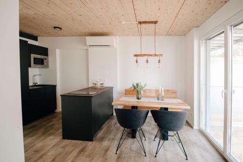 a kitchen with a wooden table and two bar stools at BrombachSeeZeit in Pleinfeld