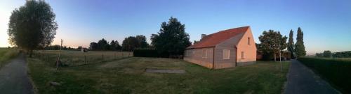 a small house in a field next to a fence at B&B De Pethaan in Wielsbeke