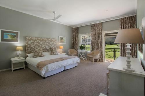 een grote slaapkamer met een bed en een patio bij 19th Hole Guest Lodge - Golfers paradise in Hermanus
