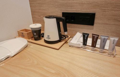 a coffee maker and cups on a table at LABE Hotel in Jeonju