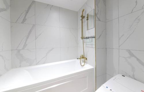 a white bathroom with a tub and a toilet at LABE Hotel in Jeonju