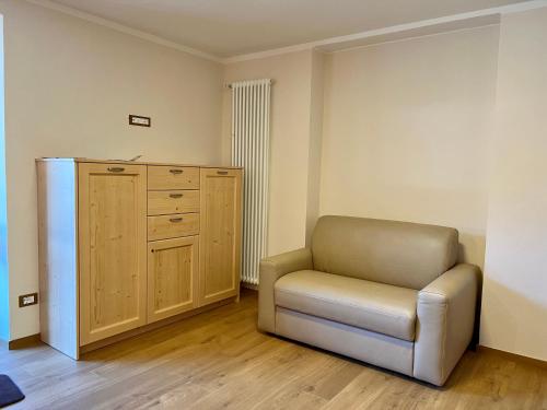 a living room with a chair and a dresser at EMARGHE, CASA A MOENA in Moena