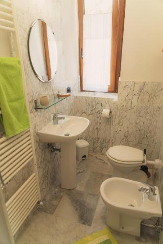 a bathroom with a sink and a toilet and a mirror at Agriturismo Tripala in Minucciano