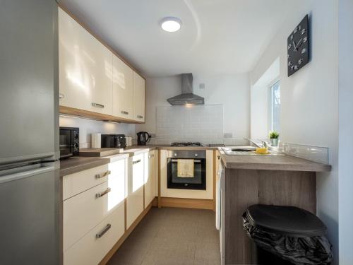 uma cozinha com armários brancos e uma bancada em Apex Living NE - Beachville House II 4 Beds FREE PARKING em Sunderland