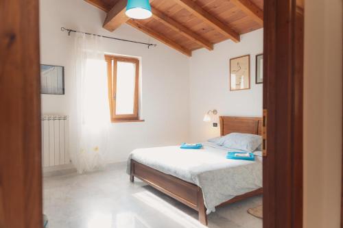 a bedroom with a bed with white sheets and a window at Agriturismo Tripala in Minucciano