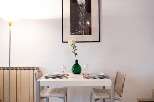 a white table with a vase with a flower in it at Cà Paola Cozy Venice Apartment in Venice