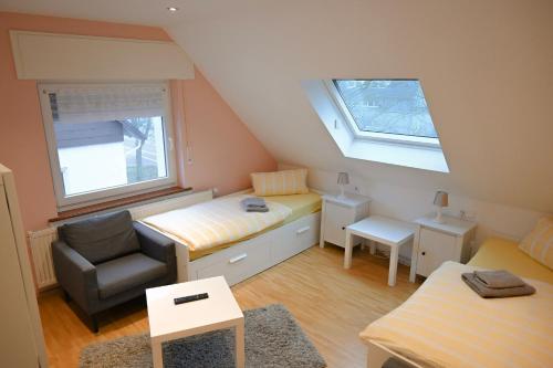 カールスルーエにあるGästehaus Windheim (Karlsruhe-Knielingen)のベッドと椅子付きの小さな部屋です。