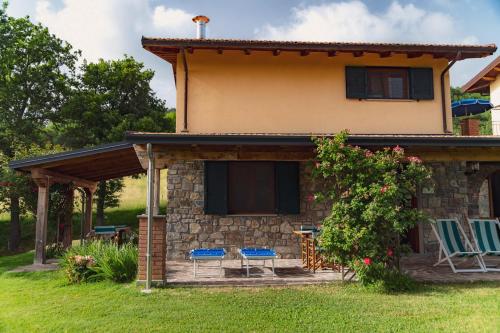 a house with two chairs and a patio at Agriturismo Tripala in Minucciano