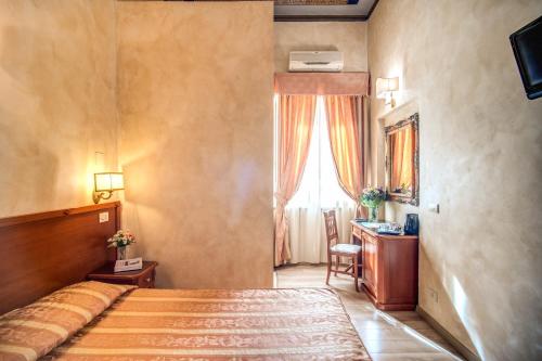 a bedroom with a bed and a desk and a window at Hotel Labelle in Rome