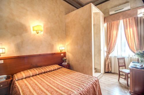 a bedroom with a bed and a desk and a window at Hotel Labelle in Rome