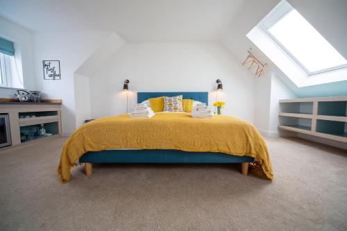 a bedroom with a bed with a yellow bedspread at The Coffee Loft in Padstow