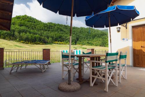 a table and chairs with an umbrella on a patio at Agriturismo Tripala in Minucciano
