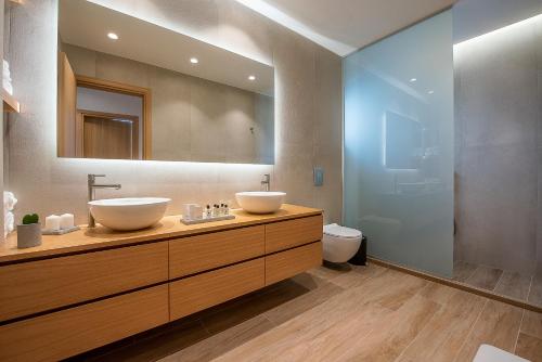 a bathroom with two sinks and a toilet at Ligaria Mare in Agia Pelagia