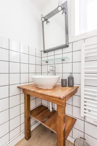 une salle de bain avec un lavabo blanc et un miroir dans l'établissement Maison Alice /Maison avec vue sur les champs, à Comines