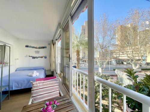 einen Balkon mit einem Bett und einem Fenster in der Unterkunft Blue Apartment in Benidorm