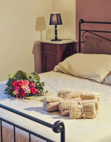 a bed with a bouquet of flowers on it at Residenza il palazzo dal 1894 in Pugliano