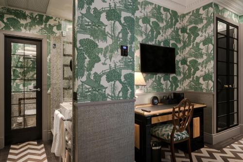 a bathroom with a desk and a tv on a wall at Relais & Châteaux Heritage Hotel in Madrid