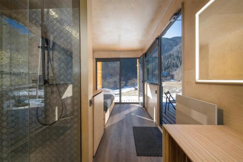 a bathroom with a shower and a glass wall at ROOMBOX Likani in Borjomi