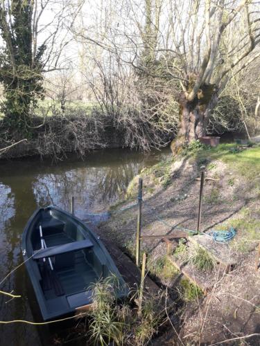 a boat sitting on the side of a river at Logis de LANGE studio 2 p in Saint-Hilaire-la-Palud